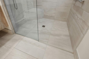 Luxury NH bathroom remodel by Shapiro Bathrooms & More. Walk in frameless shower with matching marble floor and wall tiles installed.