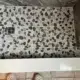 Sliced river rock mosaic shower floor in shades of charcoal and tan with a square stainless steel drain, showcasing a slip-resistant and organic design for a custom NH bathroom renovation