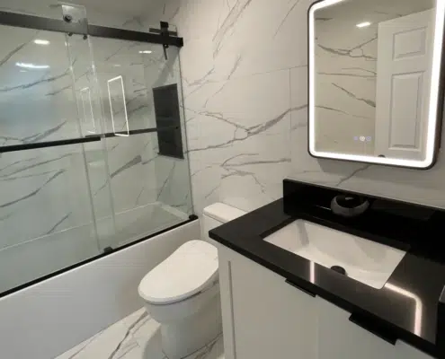 Modern bathroom remodel in Concord, NH featuring a shower-to-tub conversion, white vanity, and an LED smart mirror.