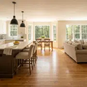 30-percent-rule Remodeled open-concept kitchen and living area featuring new oak hardwood floors, natural sunlight, and freshly painted neutral walls in a traditional New Hampshire home, showcasing high-value renovation using the 30 percent rule.