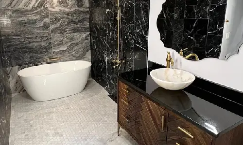 Shapiro Bathrooms & More elegant bath inspiration for homes in Southern New Hampshire. Bathroom includes a soaking tub, marble tile, gold fixtures and a vessel sink.